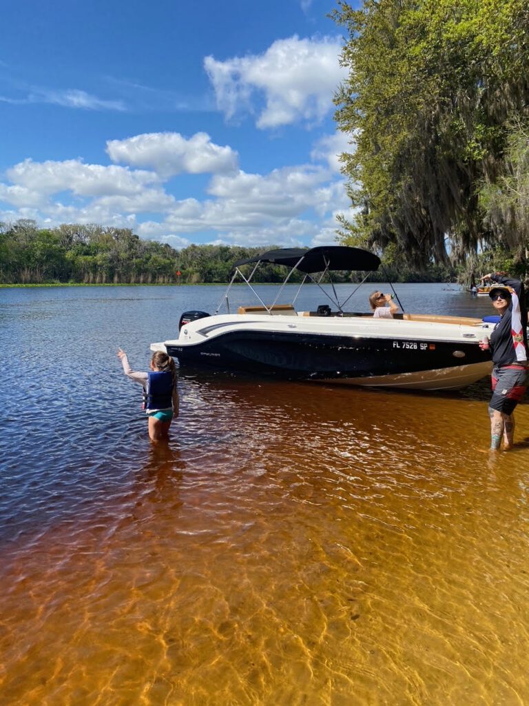 Family enjoying a day cruising and swimming on the scenic St. Johns River in Central Florida, heading toward Jacksonville