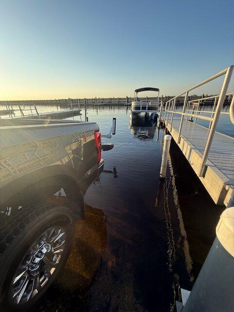 Truck and trailer at the boat ramp with the rental pontoon already launched