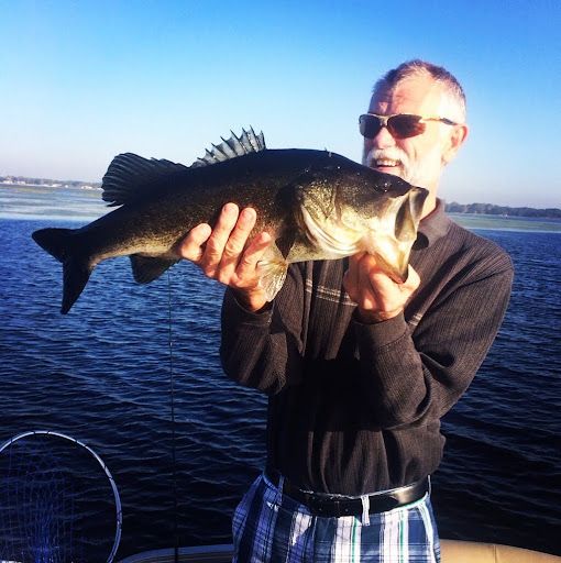 Guest holding a largemouth bass caught while fishing on West Lake Toho